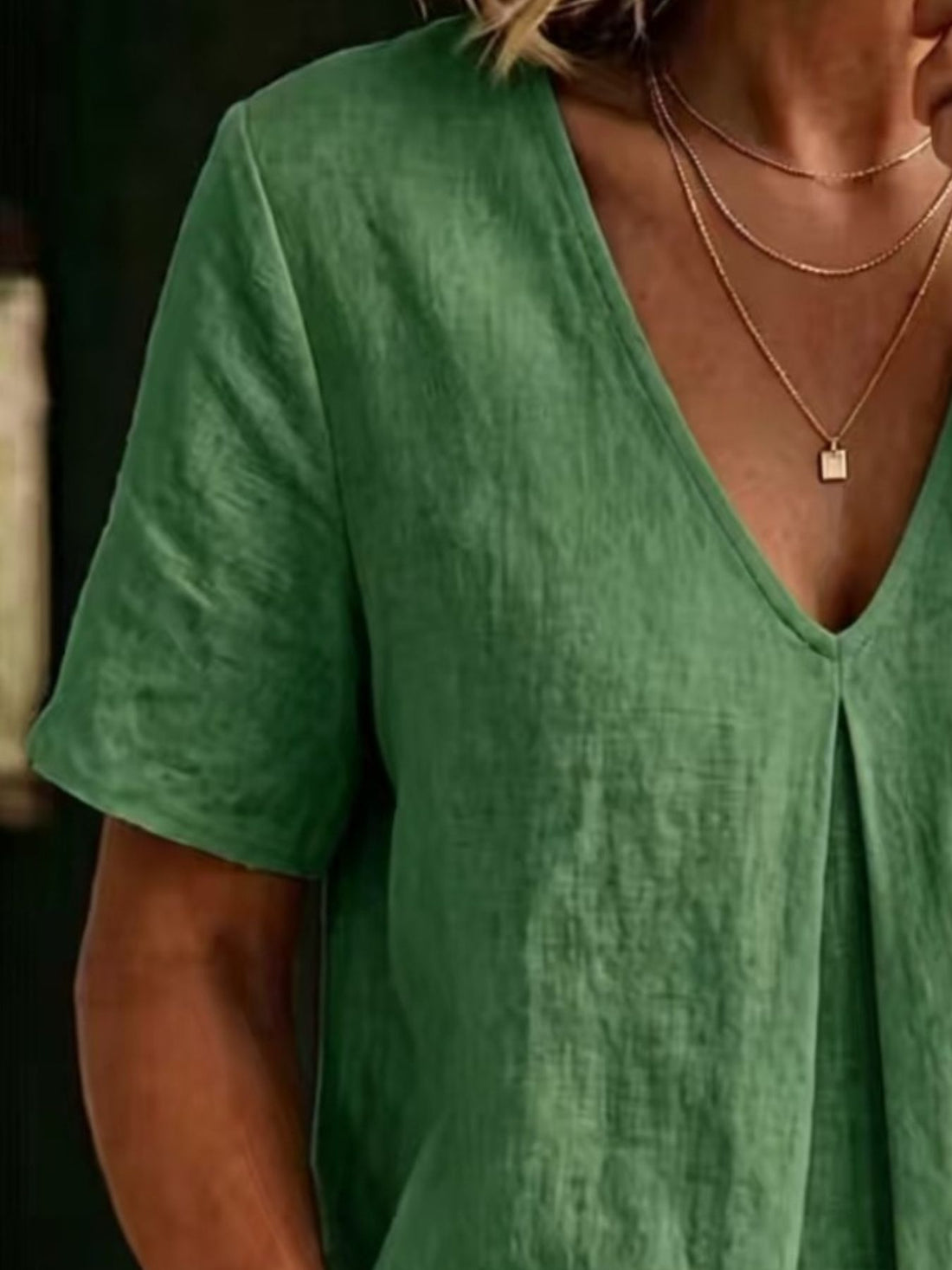 Green linen blend v-neck short sleeve top with subtle pleating detail