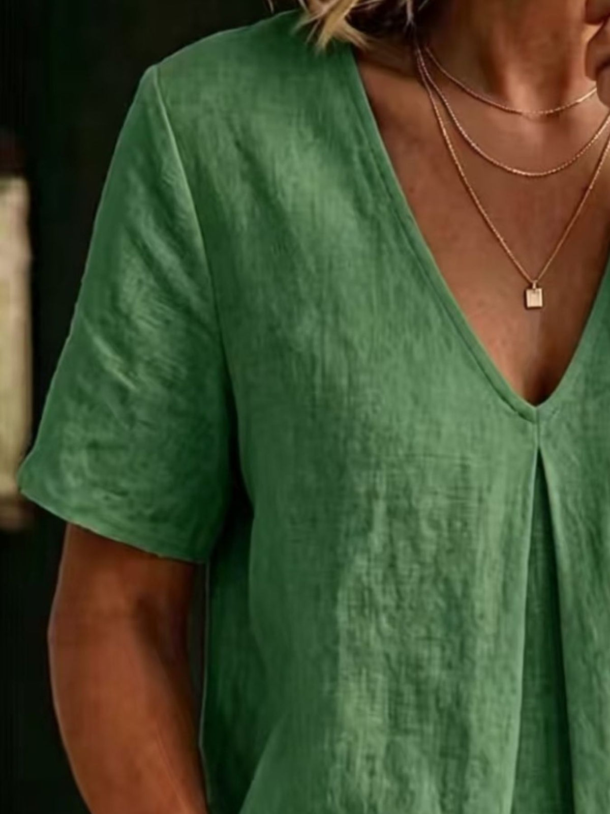 Green linen blend v-neck short sleeve top with subtle pleating detail