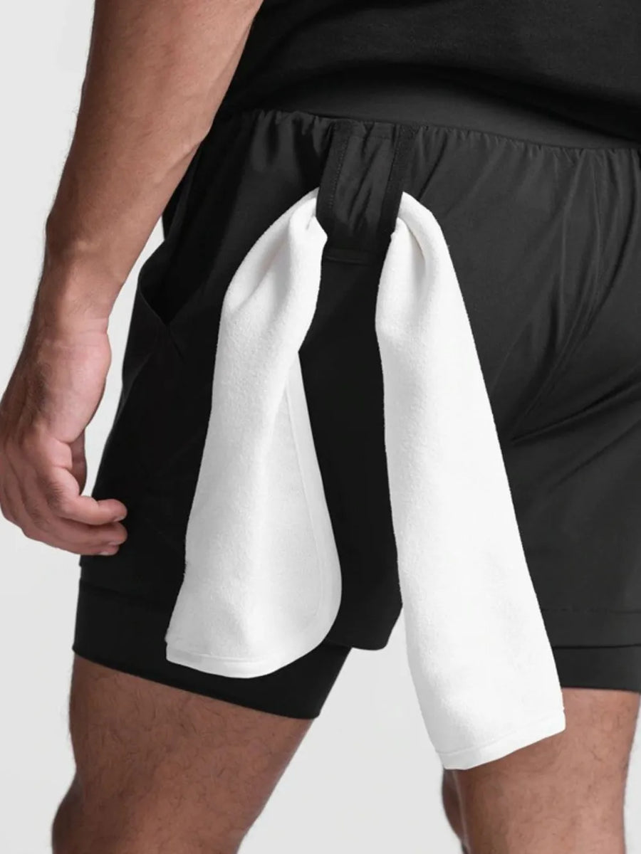 Black layered performance shorts with perforated panels and a towel loop detail.