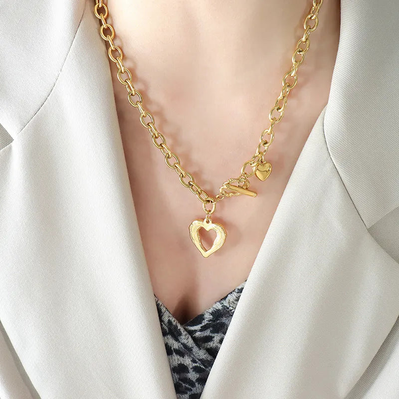 Gold chunky chain necklace with open heart pendant and toggle clasp.