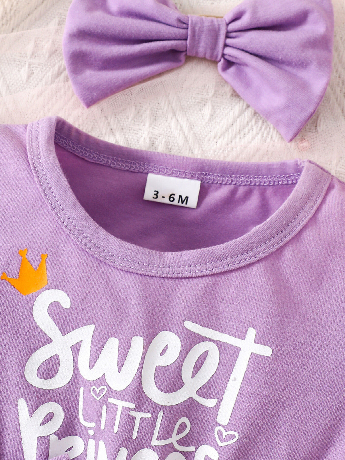 Purple baby dress with "Sweet Little Princess" graphic and matching bow headband.