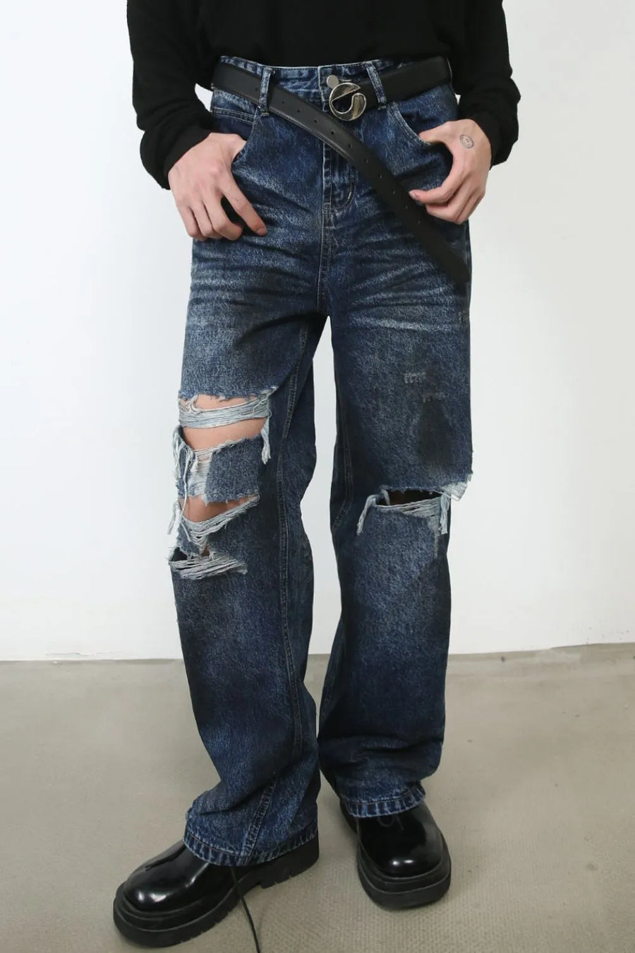 Dark wash denim jeans with distressed rips and a relaxed fit.