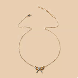 Gold bowknot pendant necklace with clear crystals on a delicate chain