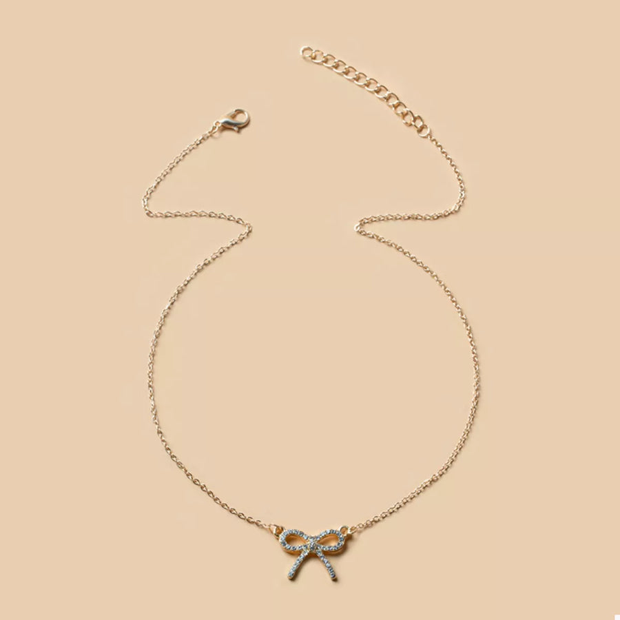 Gold bowknot pendant necklace with clear crystals on a delicate chain