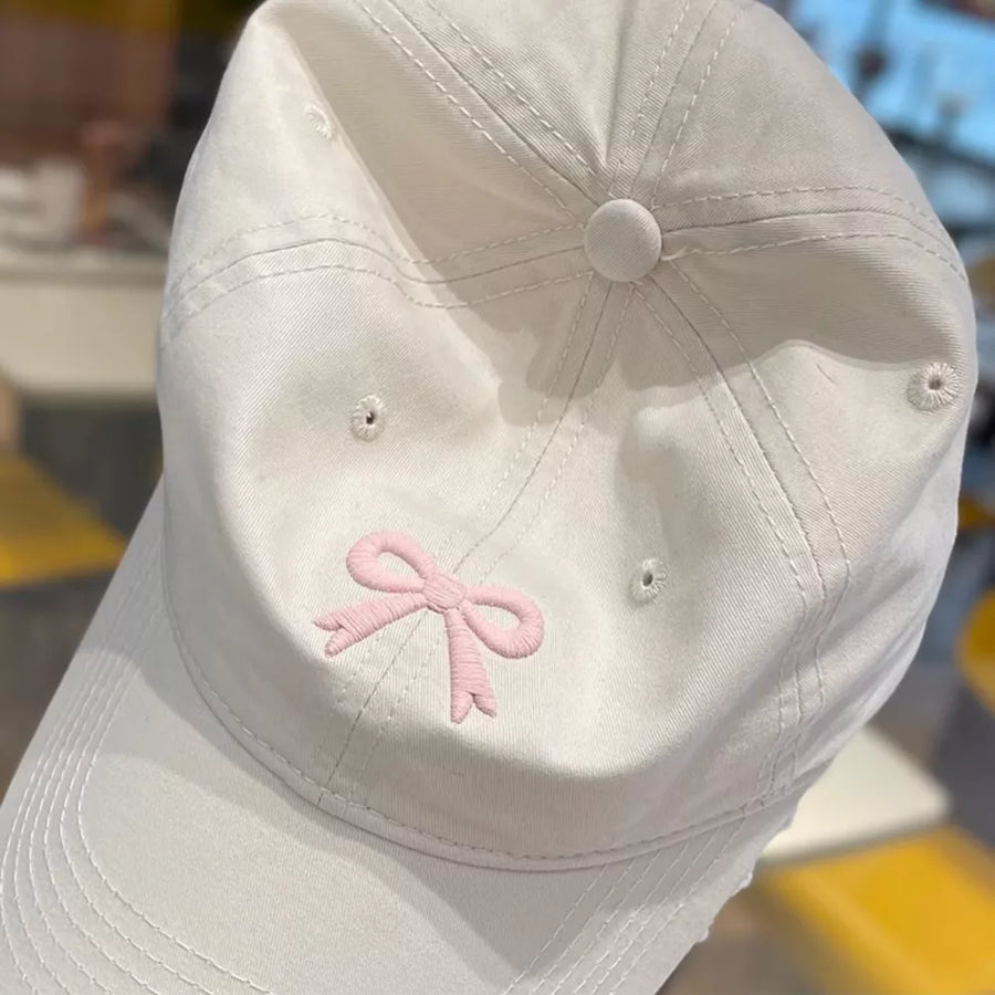 Beige baseball cap with pink embroidered bow detail