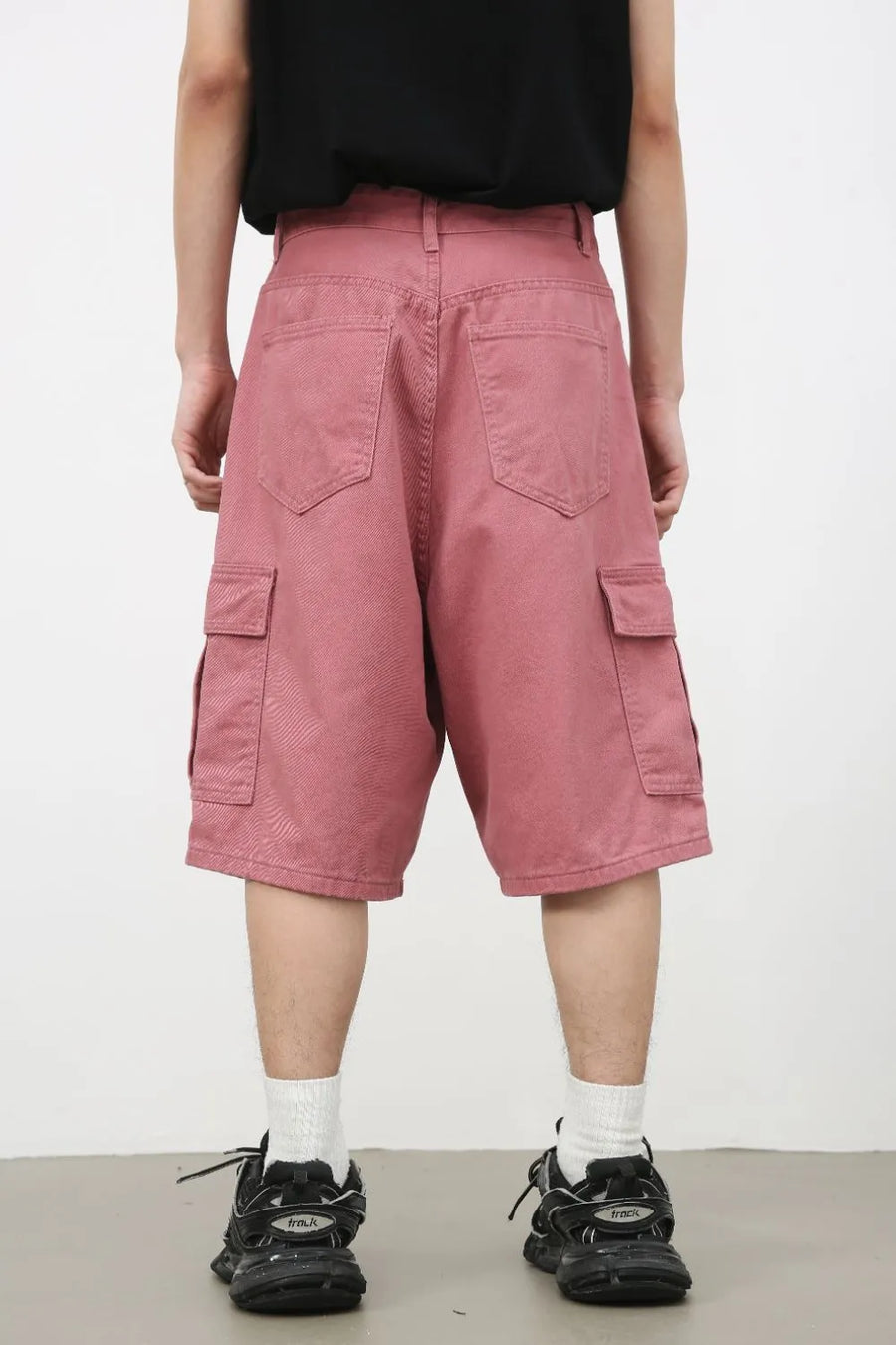 Magenta baggy cargo bermuda shorts with textured fabric and multiple pockets.