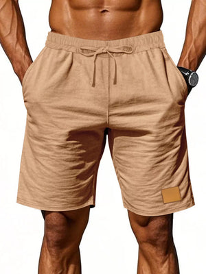 Light Khaki chino shorts with drawstring waist and side pockets, featuring a small patch detail.