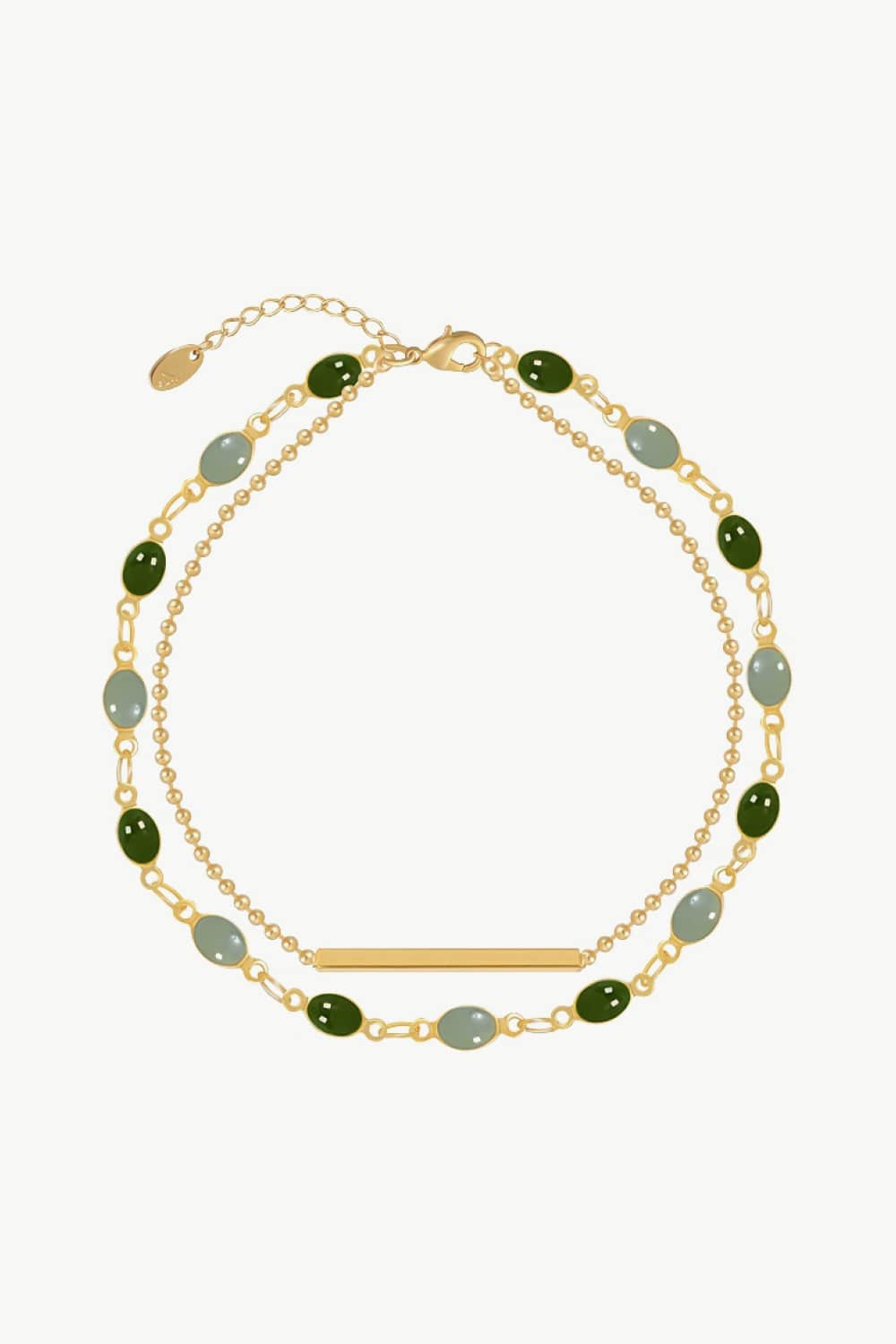 Dual chain bracelet in gold with green and grey oval stones and a gold bar accent