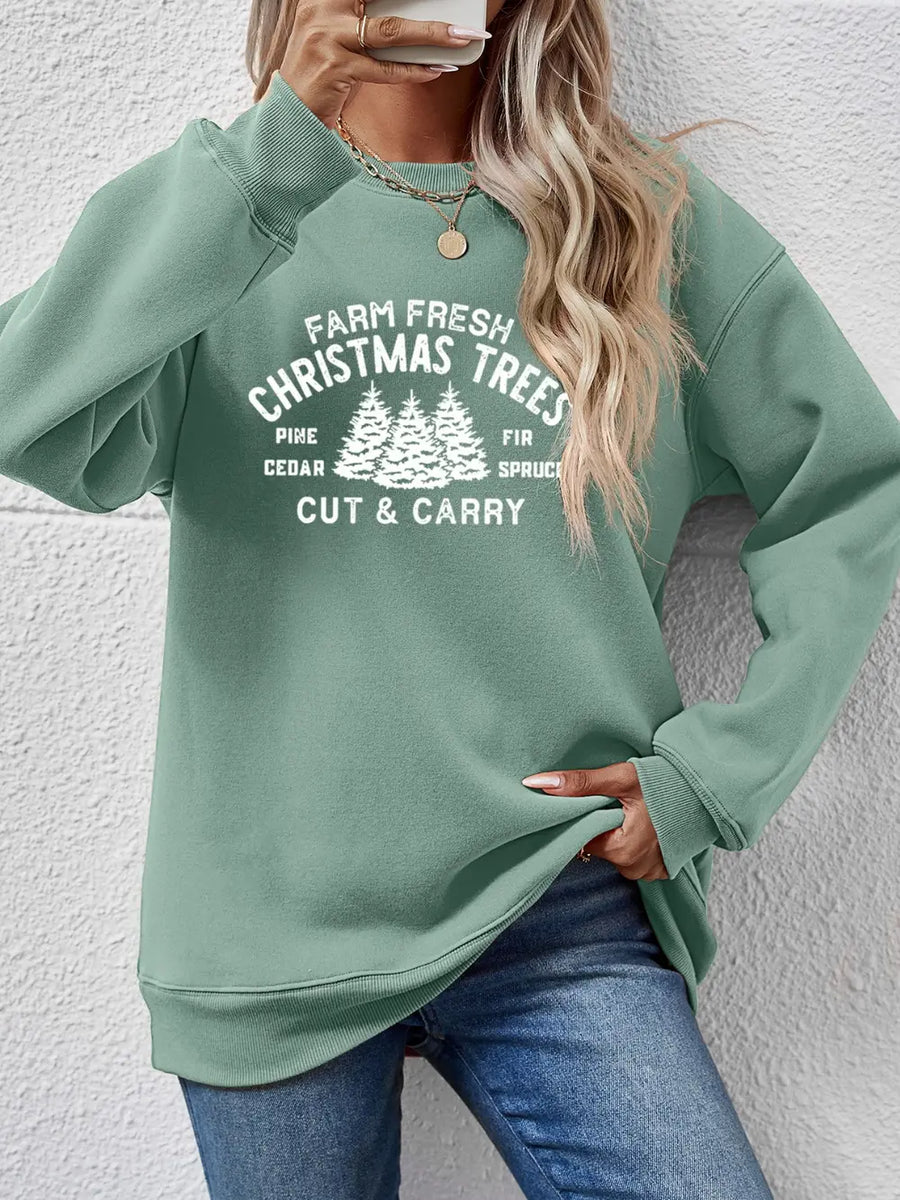 Sage green crewneck sweatshirt with white Christmas tree graphic and text.