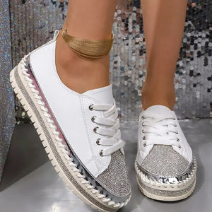 White sneakers with rhinestone toe and chunky sole, featuring silver accents and braided trim.