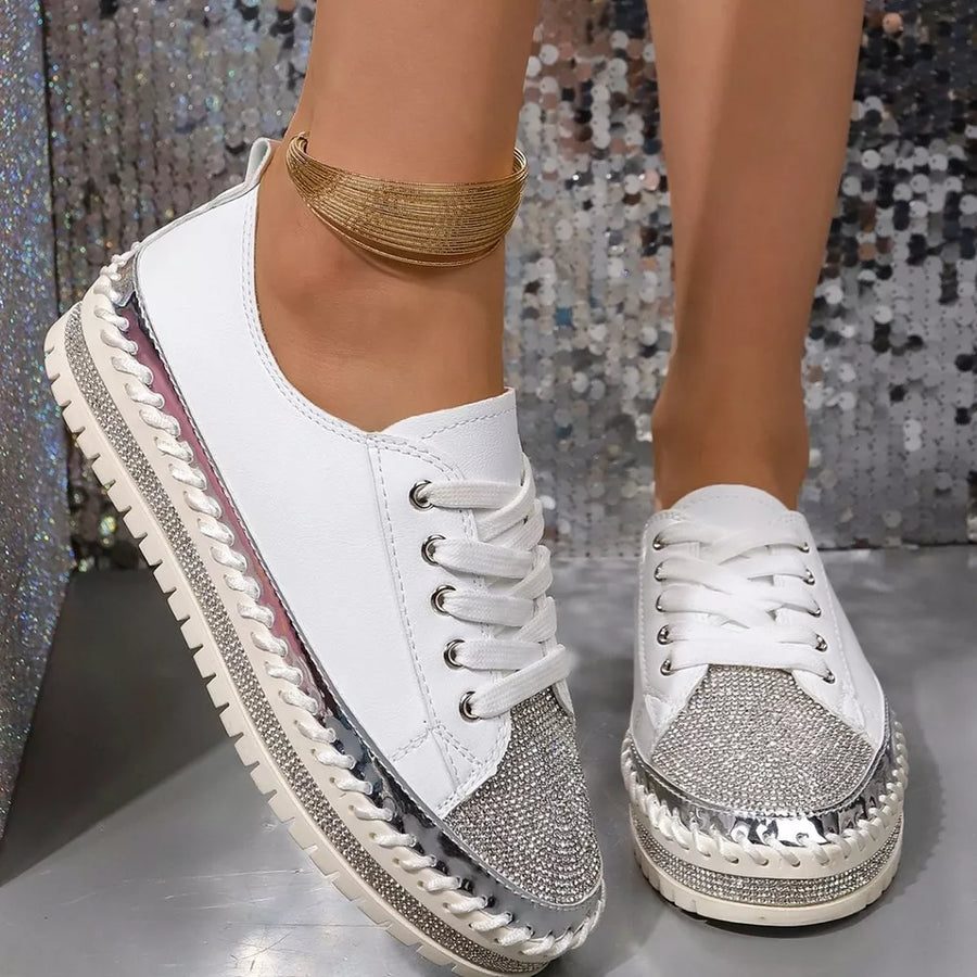 White sneakers with rhinestone toe and chunky sole, featuring silver accents and braided trim.