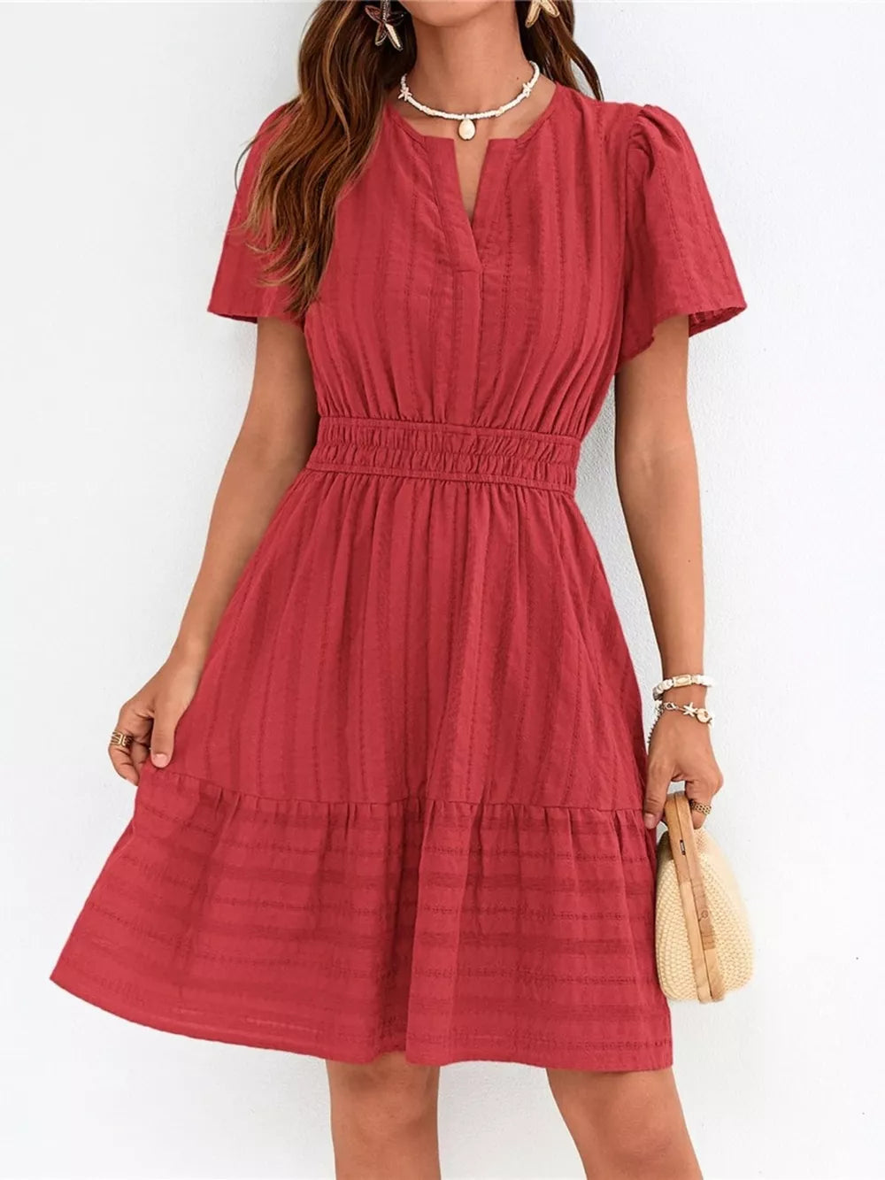 Red textured V-neck tiered dress with smocked waist and short sleeves.
