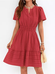 Red textured V-neck tiered dress with smocked waist and short sleeves.