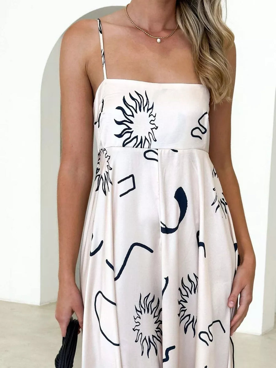Ivory spaghetti strap maxi dress with abstract sun and line print.