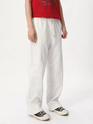 Cream cotton drawstring sweatpants with wide legs and a tailored fit.