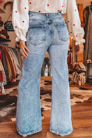 Light wash denim flare jeans with whiskering and a high waist.