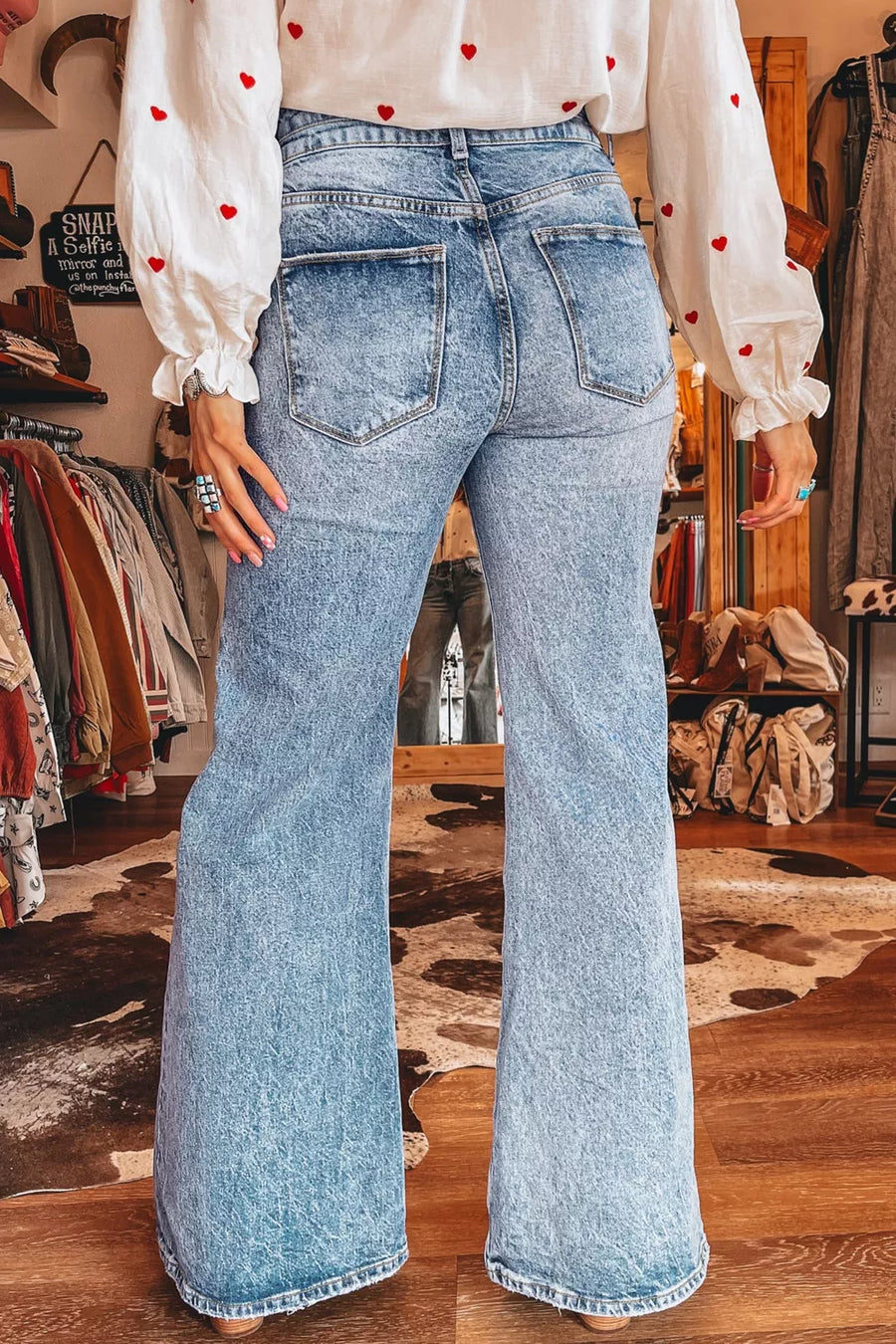 Light wash denim flare jeans with whiskering and a high waist.