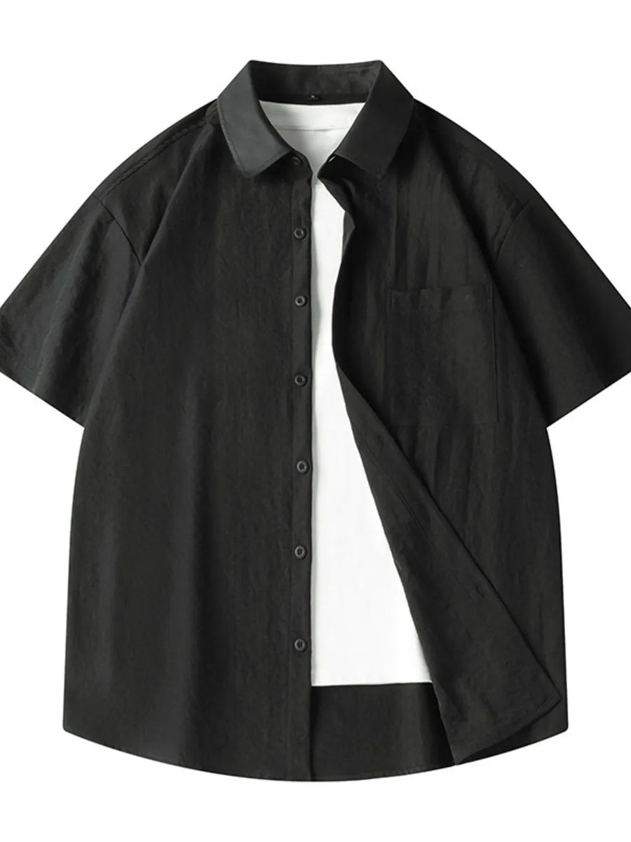 Black short sleeve button-up shirt with pocket, worn over a white t-shirt.