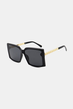 Black geometric sunglasses with gradient lenses and gold textured temples.