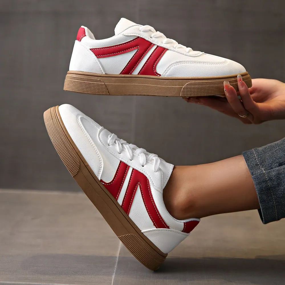 White and red suede panel sneakers with brown soles.