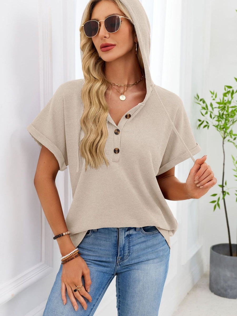 Apricot waffle knit hooded top with button placket and short sleeves.