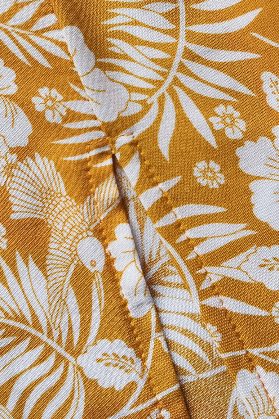 Bohemian floral print crop top and maxi skirt set in mustard yellow viscose with white tropical leaves and birds.