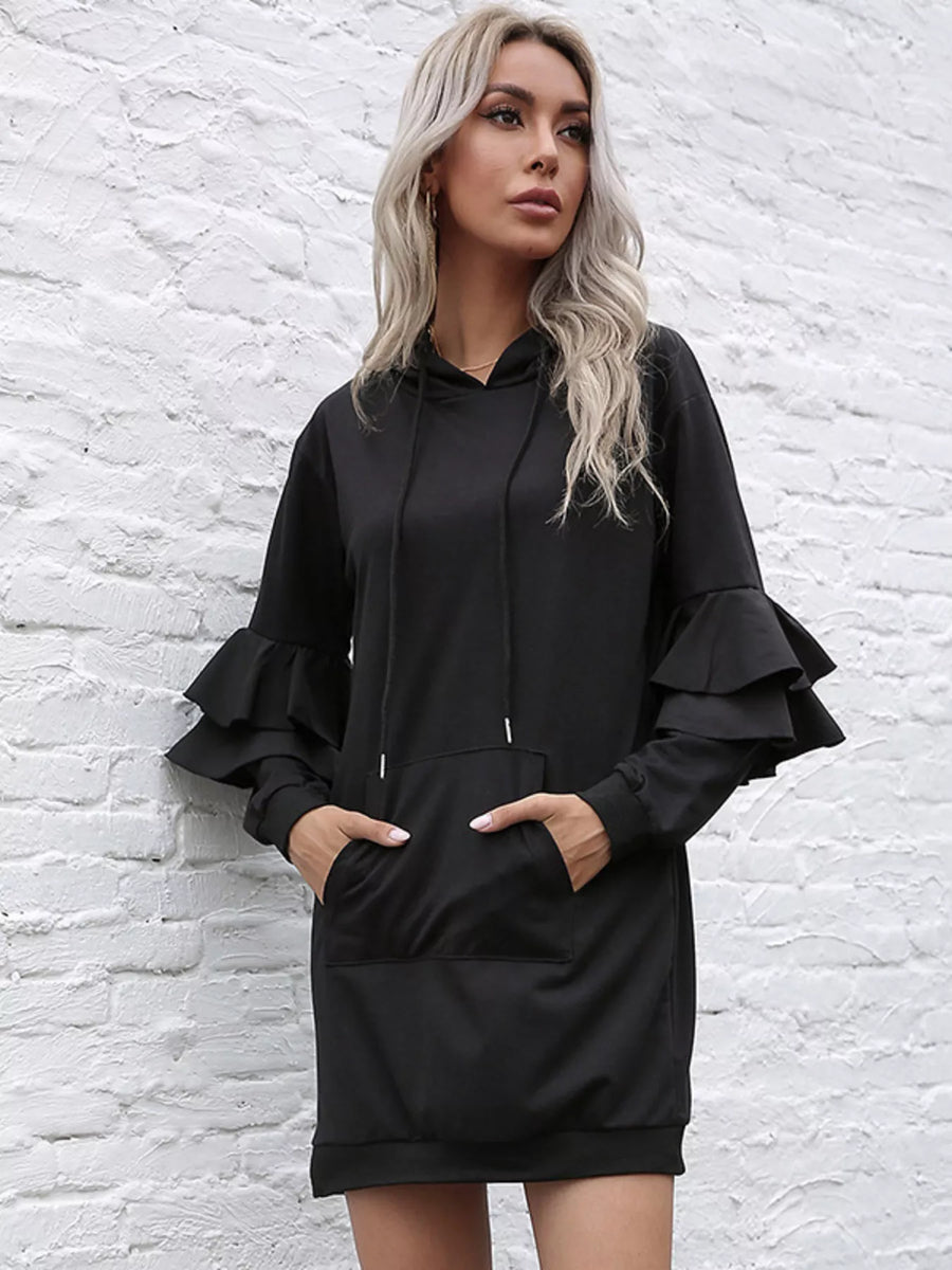Black hooded mini dress with ruffle trim sleeves and a front pocket.