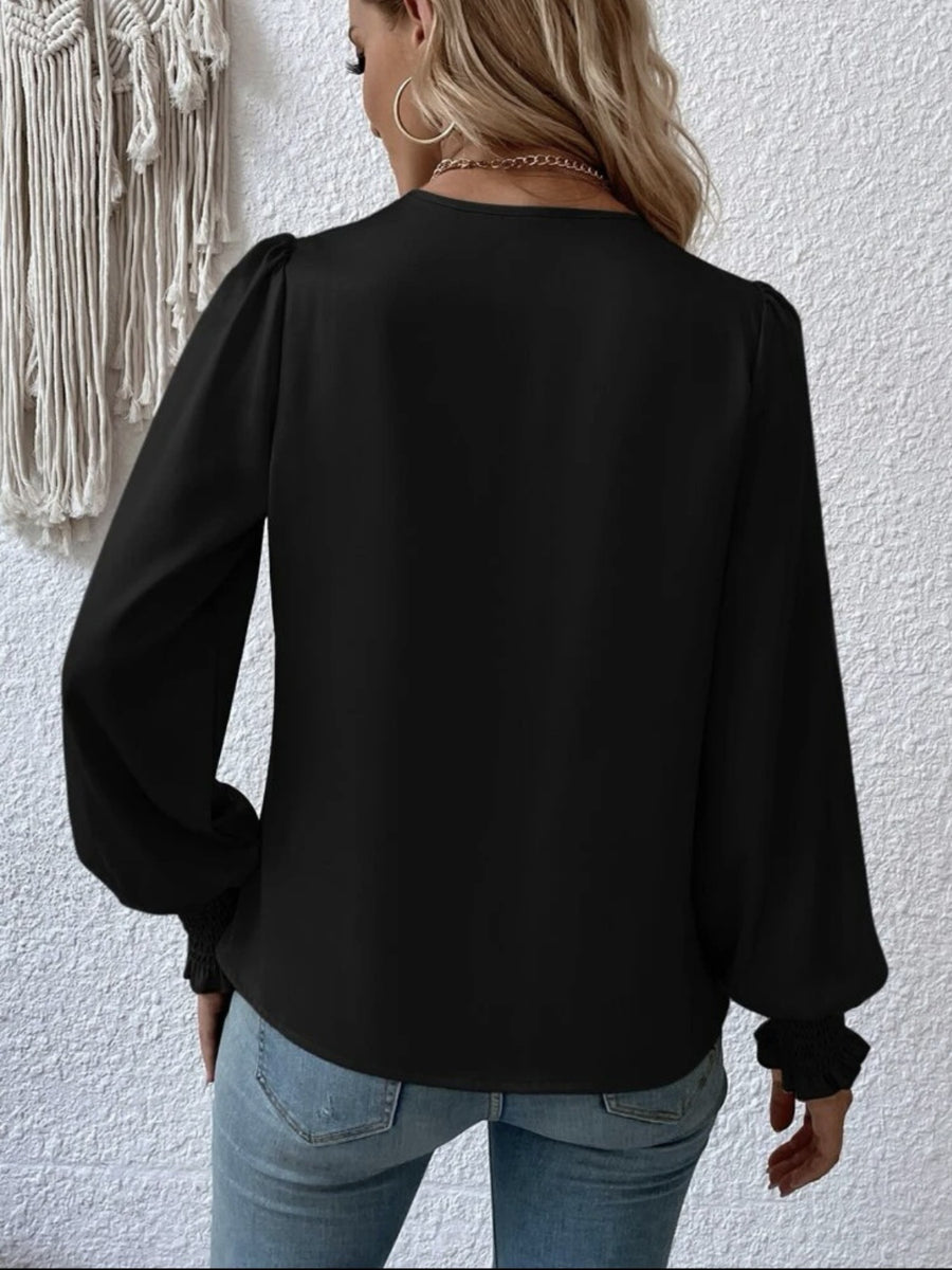 Black long sleeve blouse with ruched cuffs and puff sleeves.