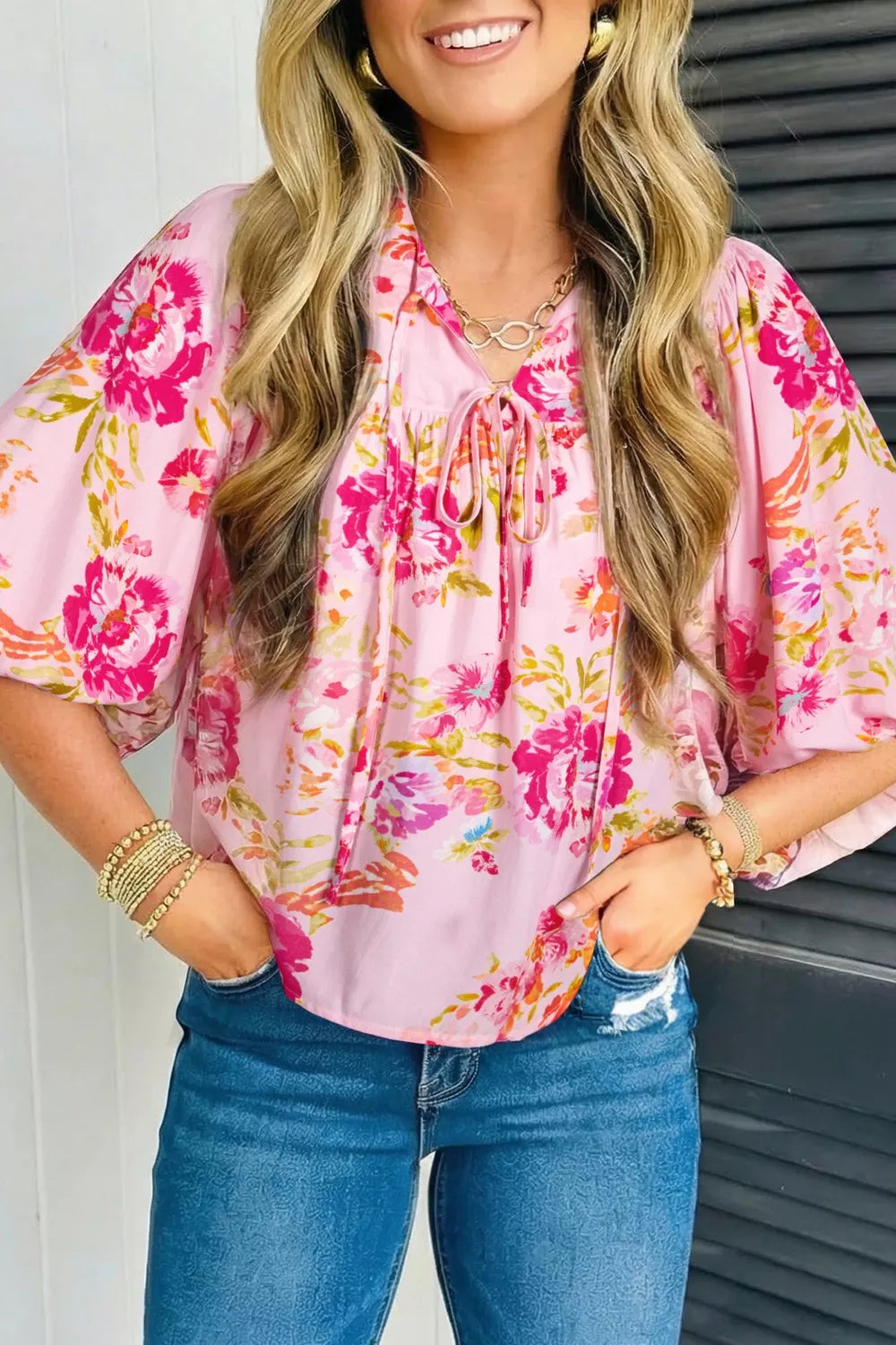 Pink floral tie-neck blouse with puff sleeves and a relaxed fit.