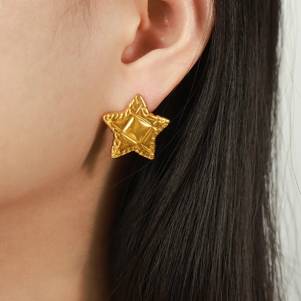 Gold textured celestial star stud earrings with a diamond pattern detail.