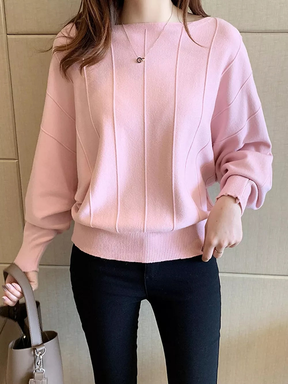 pullover sweater in light pink featuring ribbed hem and relaxed fit