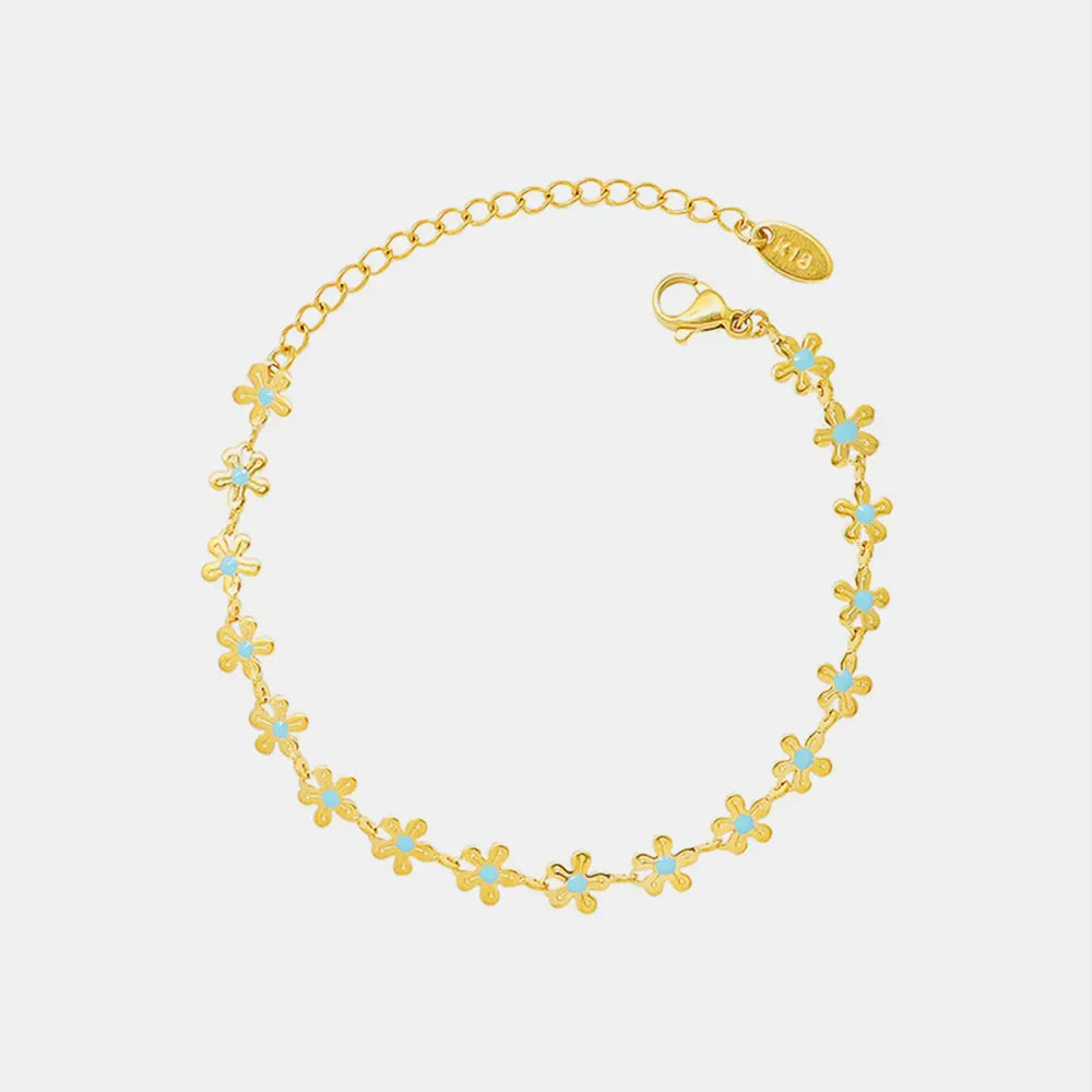 Gold daisy chain bracelet with blue enamel centers, 18K gold-plated.