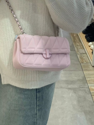 Pink quilted flap chain bag with diamond pattern and turn-lock closure.