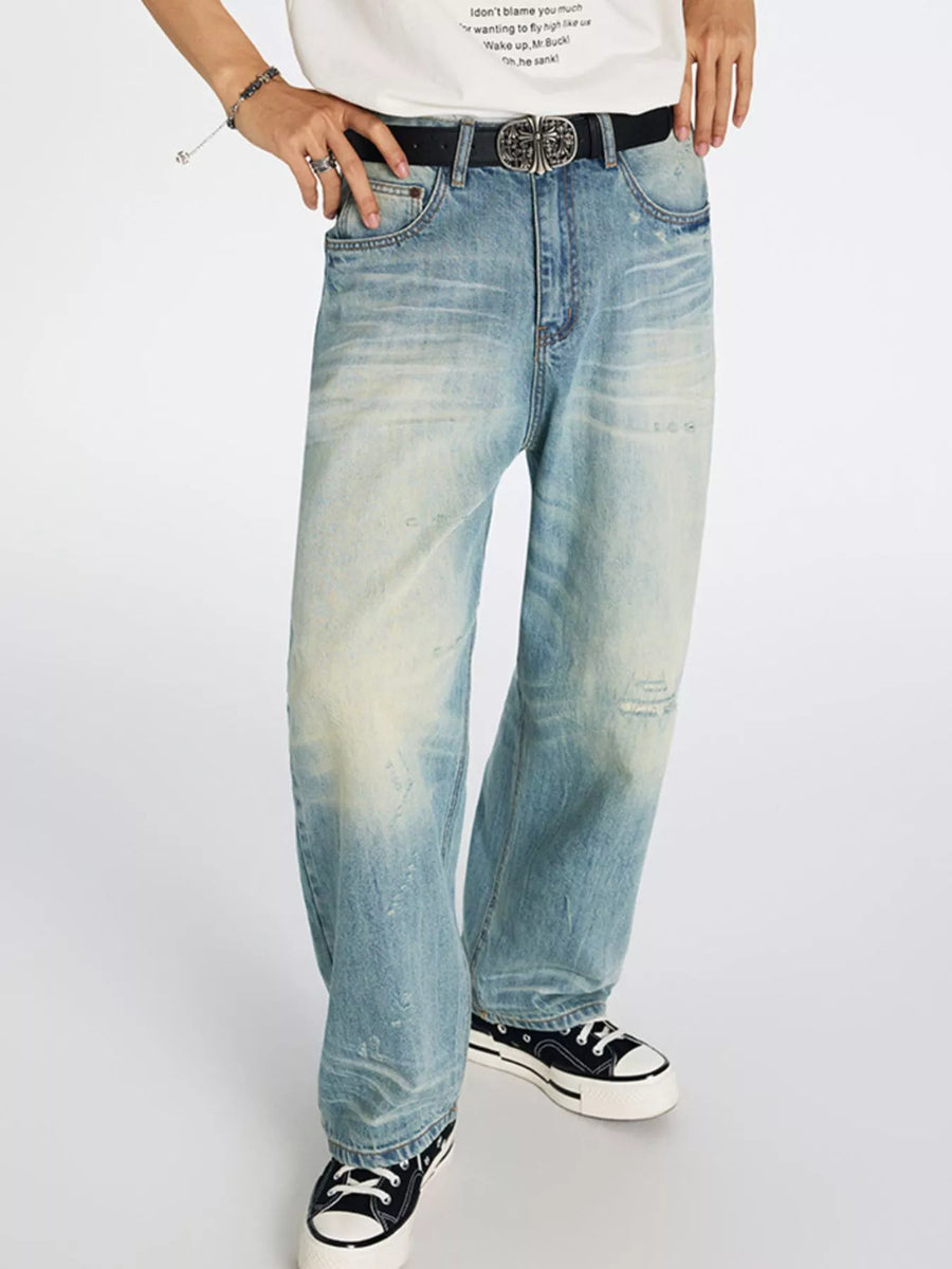 Men's light wash blue relaxed wide-leg denim jeans with distressed details and a faded effect.