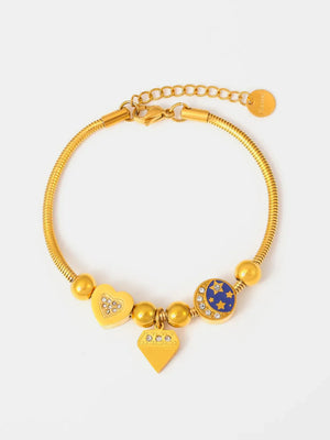 Gold celestial charm bracelet with diamond accents, featuring heart, diamond, and moon & stars charms.