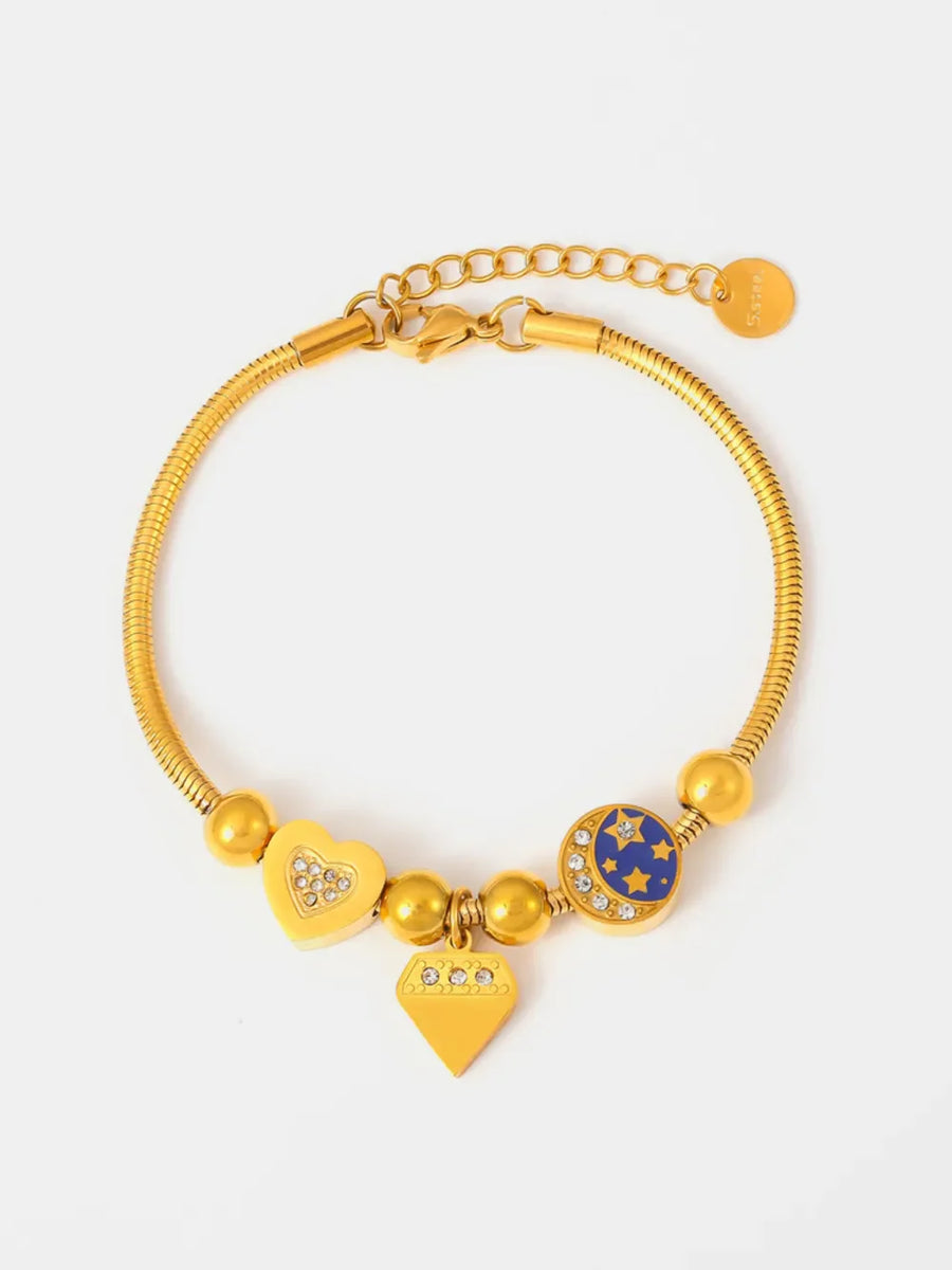 Gold celestial charm bracelet with diamond accents, featuring heart, diamond, and moon & stars charms.
