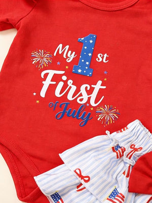 Red baby bodysuit with My 1st of July graphic and striped shorts with flag print.