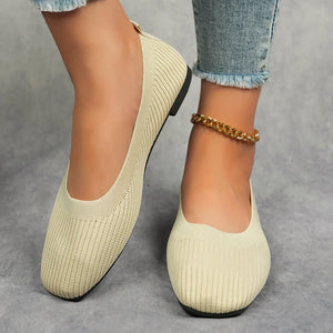 Beige knit square toe flats with a subtle ribbed texture and a gold chain anklet.