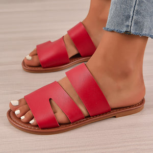 Red open toe flat sandals with three wide straps and a comfortable casual style.