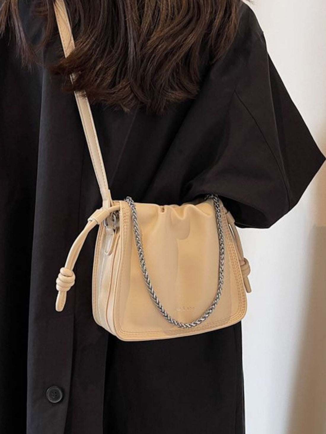 Elegant off-white ruched PU leather crossbody bag with chain detail and knotted strap