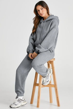 Gray relaxed fit loungewear set with hoodie and drawstring pants, featuring a front pocket.