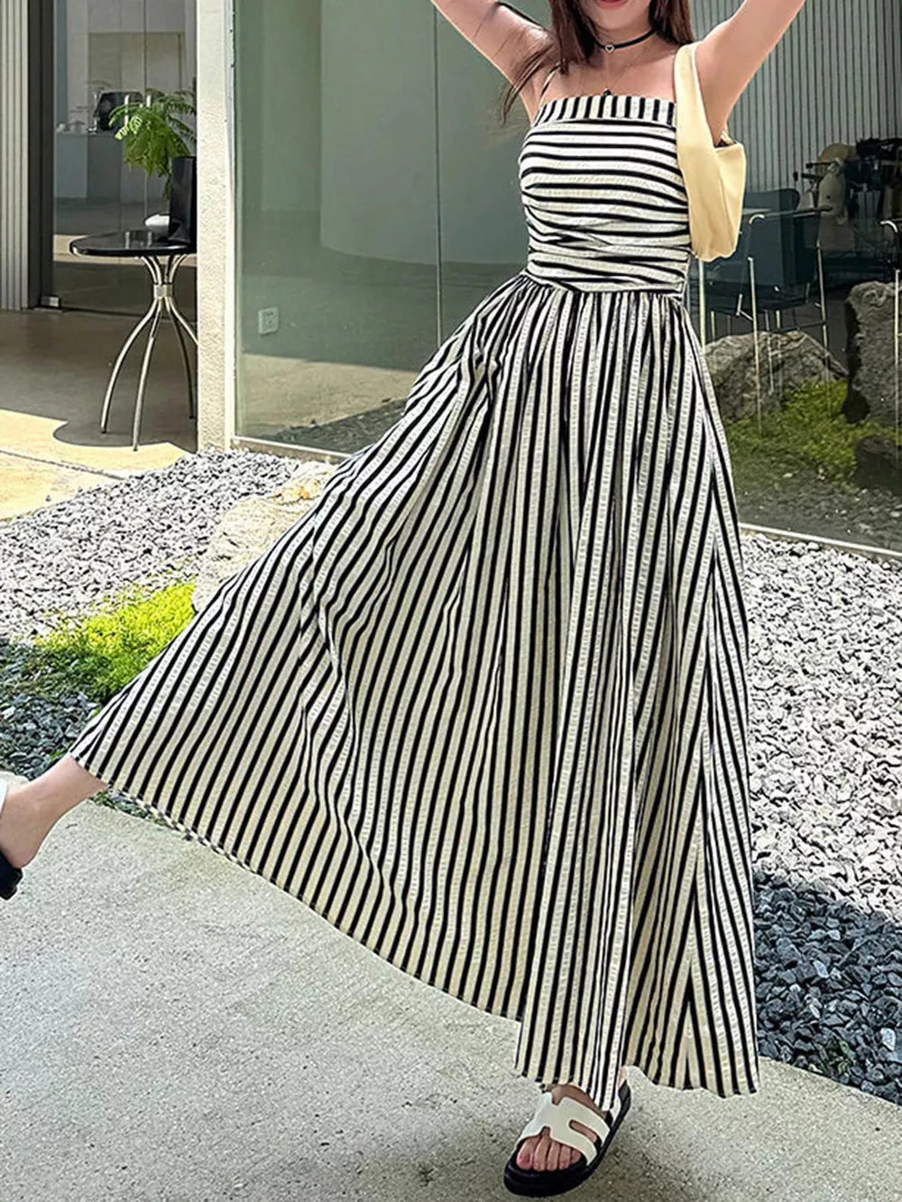 Black and white striped maxi dress with a square neckline, cinched waist, and side slit.