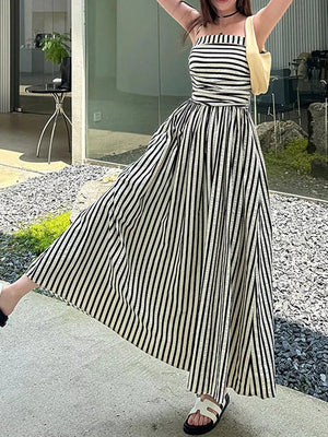 Black and white striped maxi dress with a square neckline, cinched waist, and side slit.