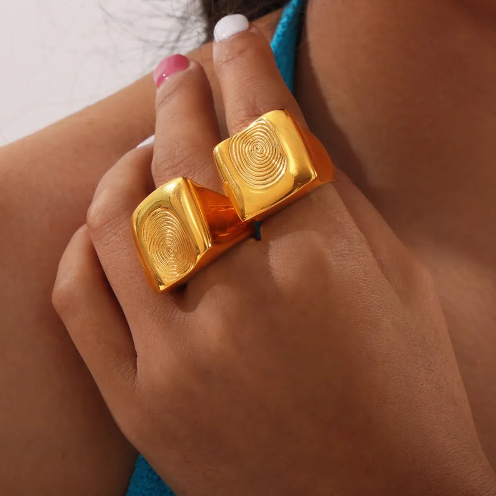 Gold sculpted fingerprint signet rings with square tops.