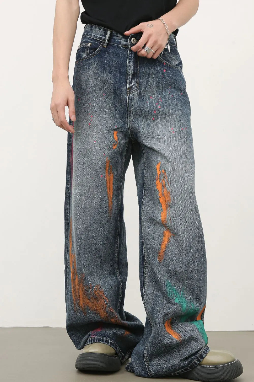 Painterly wide-leg denim jeans in medium wash with orange and pink paint splatters.
