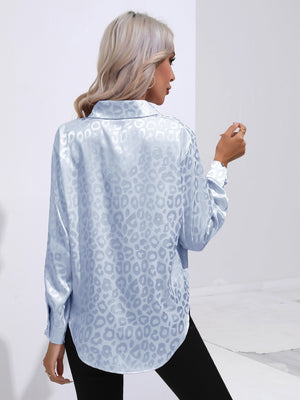 Light blue satin leopard print blouse with button cuffs and collared neckline.