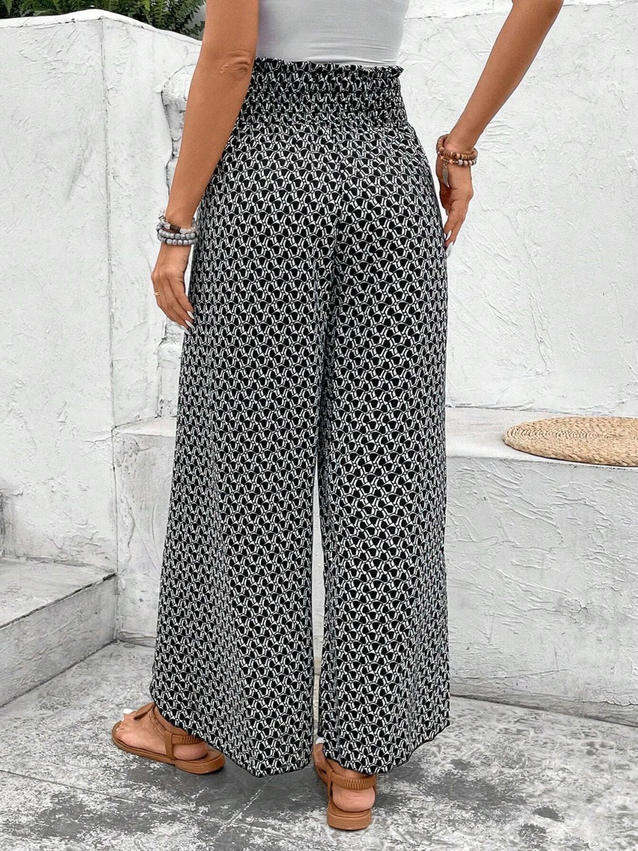 Black and white patterned palazzo pants with a smocked waist, styled with sandals.