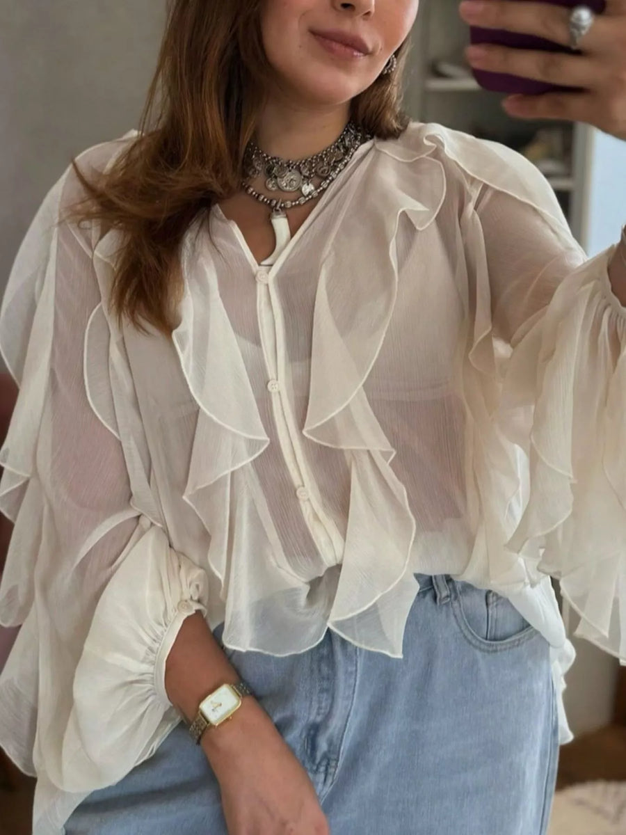 White sheer ruffled long-sleeve blouse with button front and dramatic ruffles.