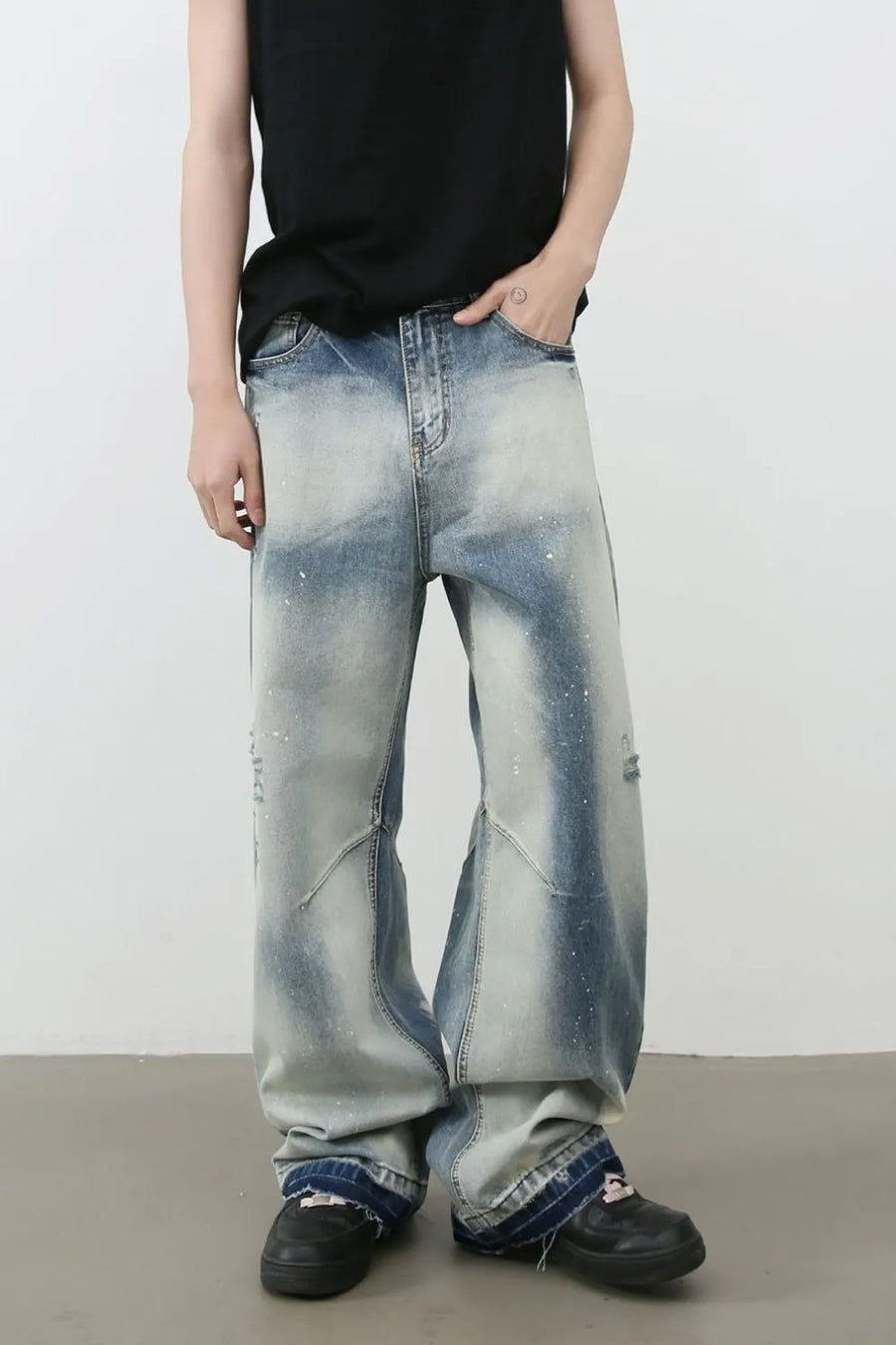 Distressed painterly wide-leg jeans in medium wash denim with paint splatters and artistic paneling.