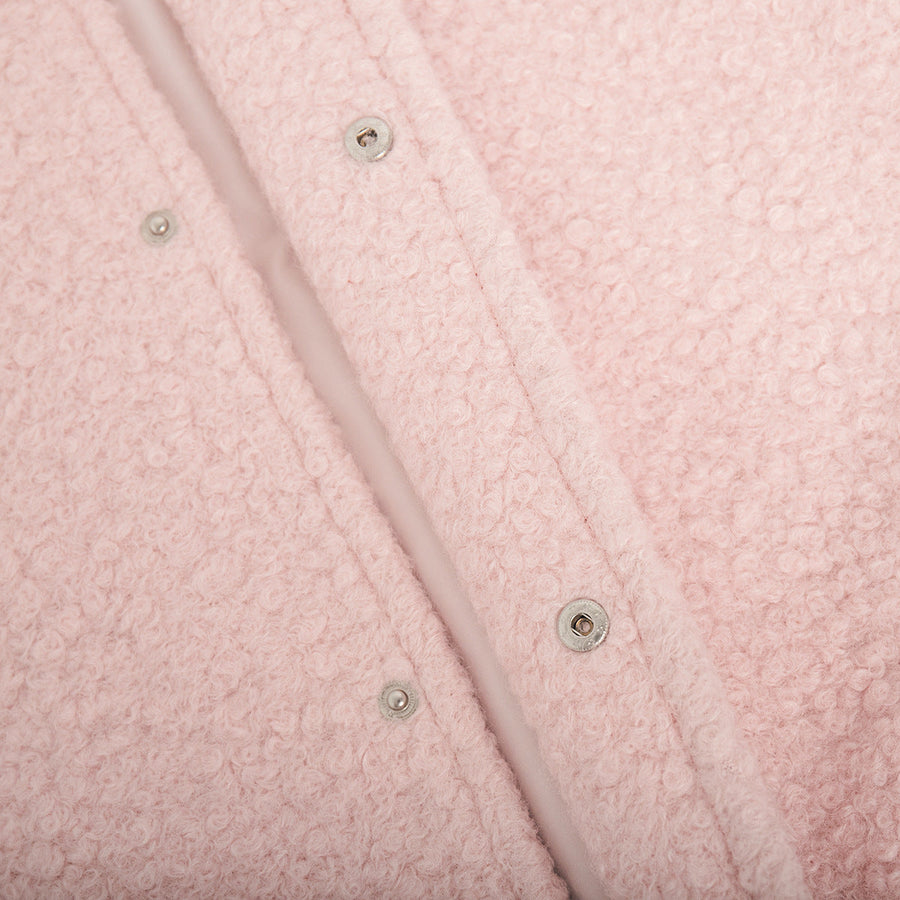 Blush pink textured bouclé bomber jacket with rounded neck and snap closures.